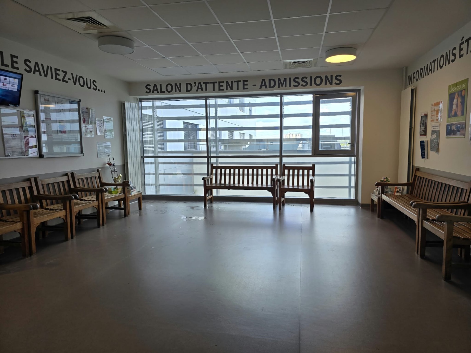 Salle d'attente des admissions de la Clinique Saint-Jean l'Ermitage à Melun après la pose du film solaire, bancs remis en place, baie vitrée toute largeur
