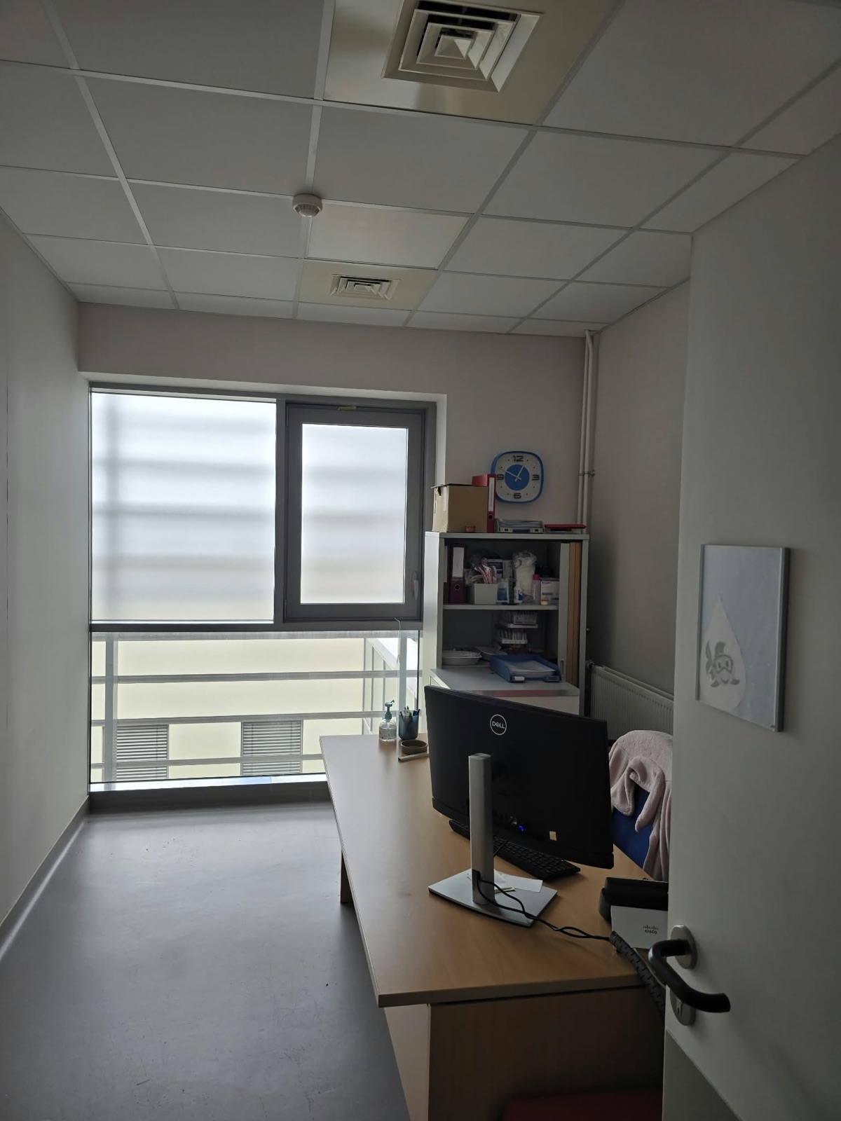 Bureau d'entretien de la Clinique Saint-Jean l'Ermitage à Melun, fenêtre toute hauteur équipée du film solaire, poste de travail face à la baie