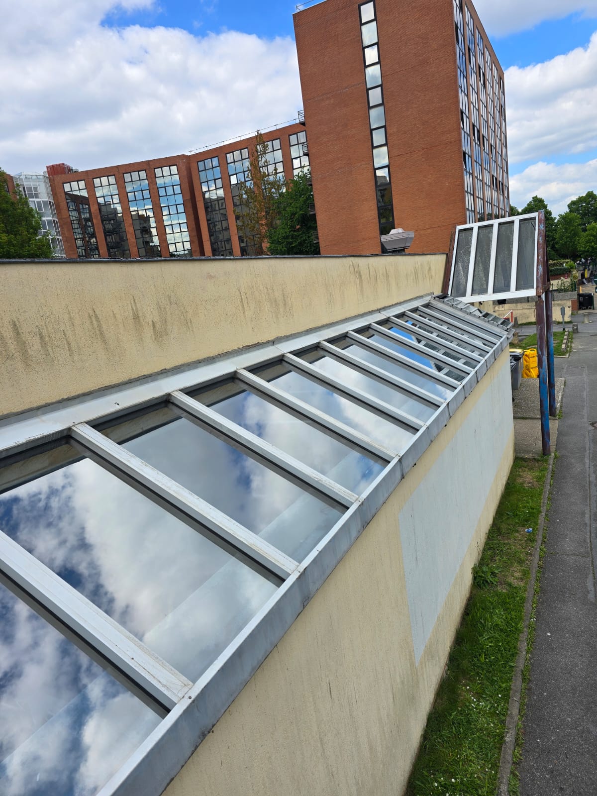Vue rapprochée de la verrière inclinée du studio Solarscène prise depuis la toiture — panneaux en sheds avant traitement, DFP France