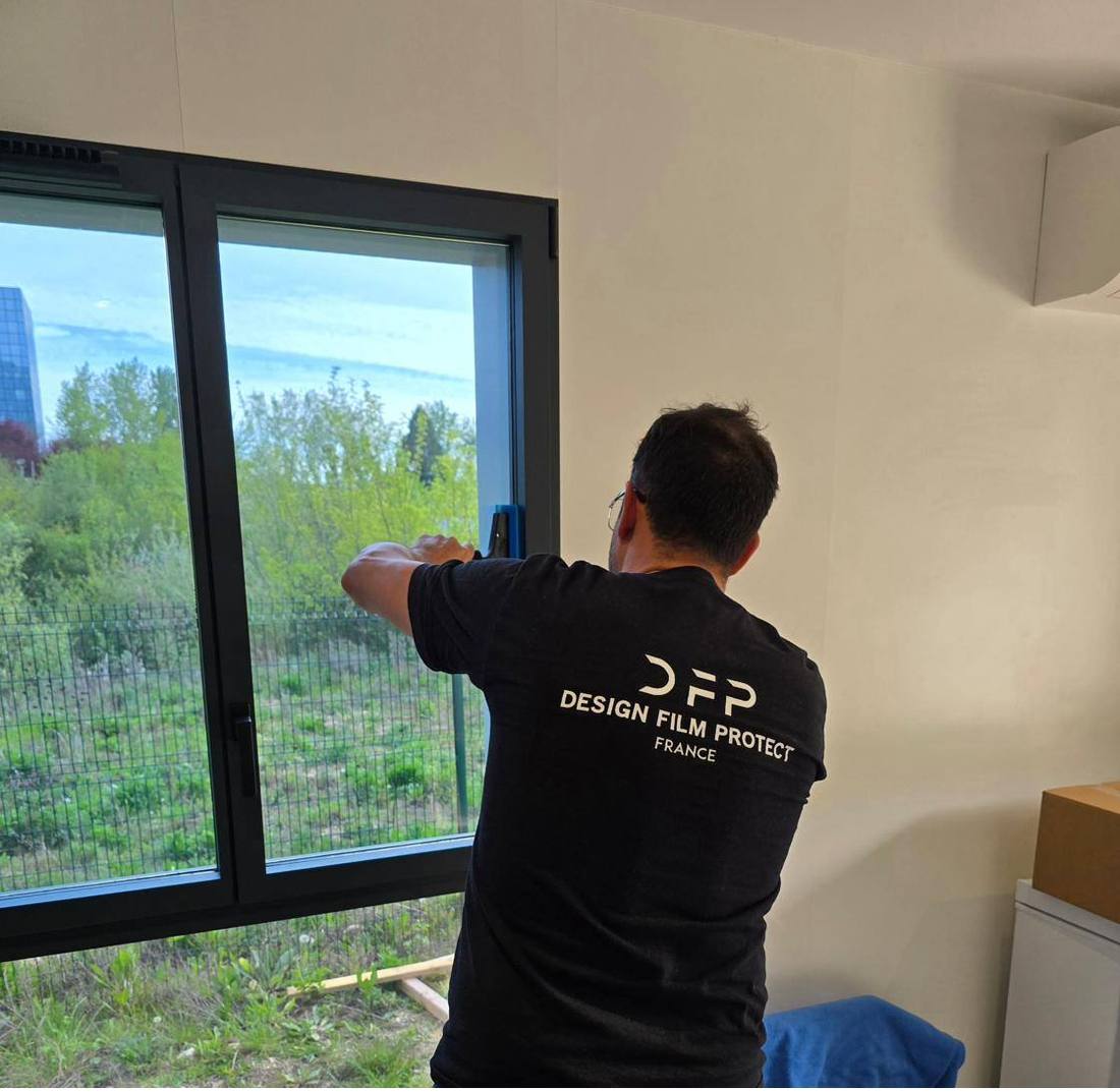 Technicien DFP France en train de poser un film sur une fenêtre de bureau